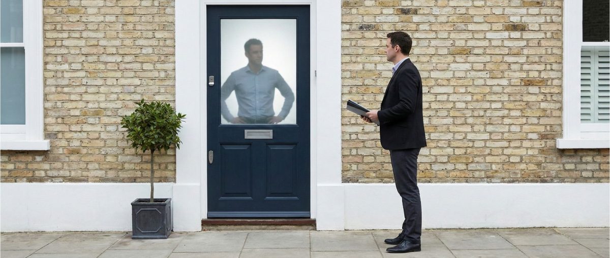 Debt Collectors Untitled design 4 Man holding documents stands outside a house, facing a closed front doo